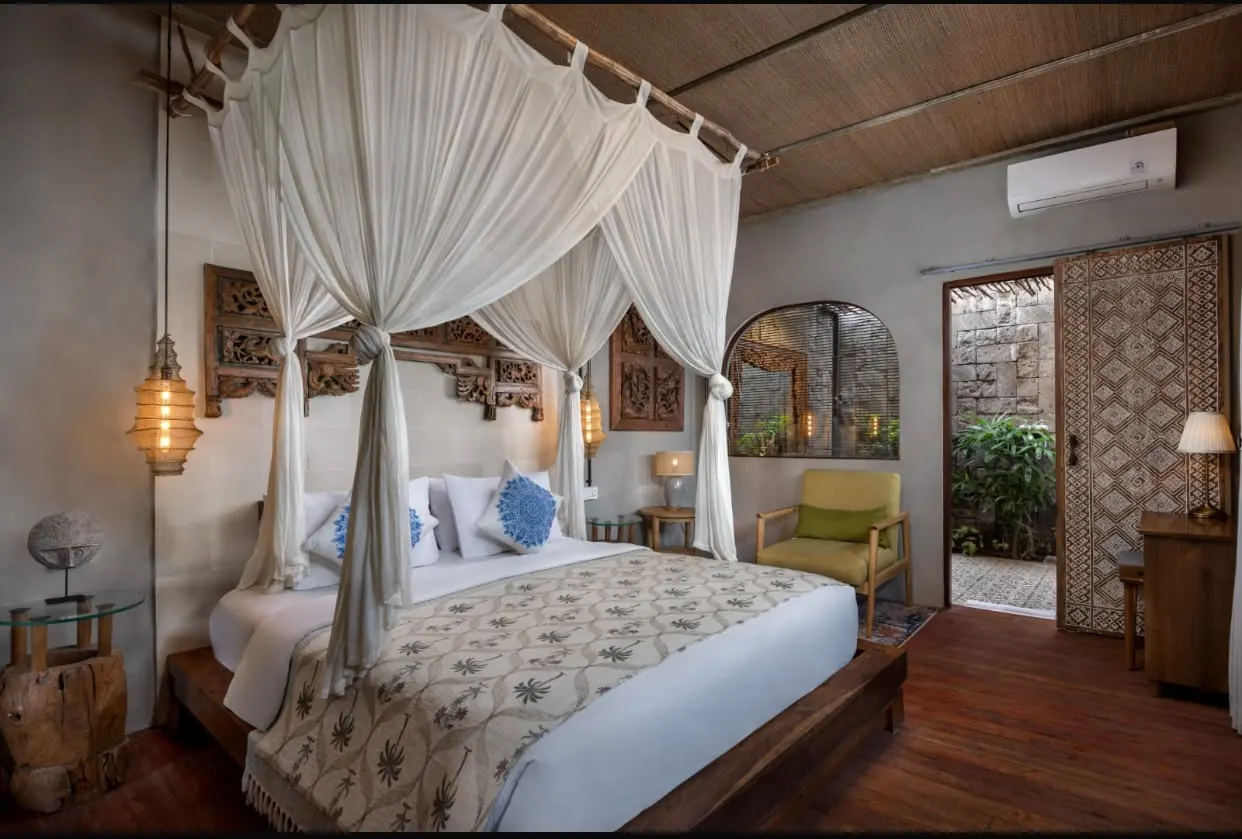 Canopy bed with sheer curtains and a carved headboard