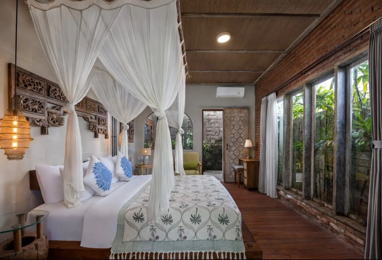Bedroom with canopy bed and tall garden windows