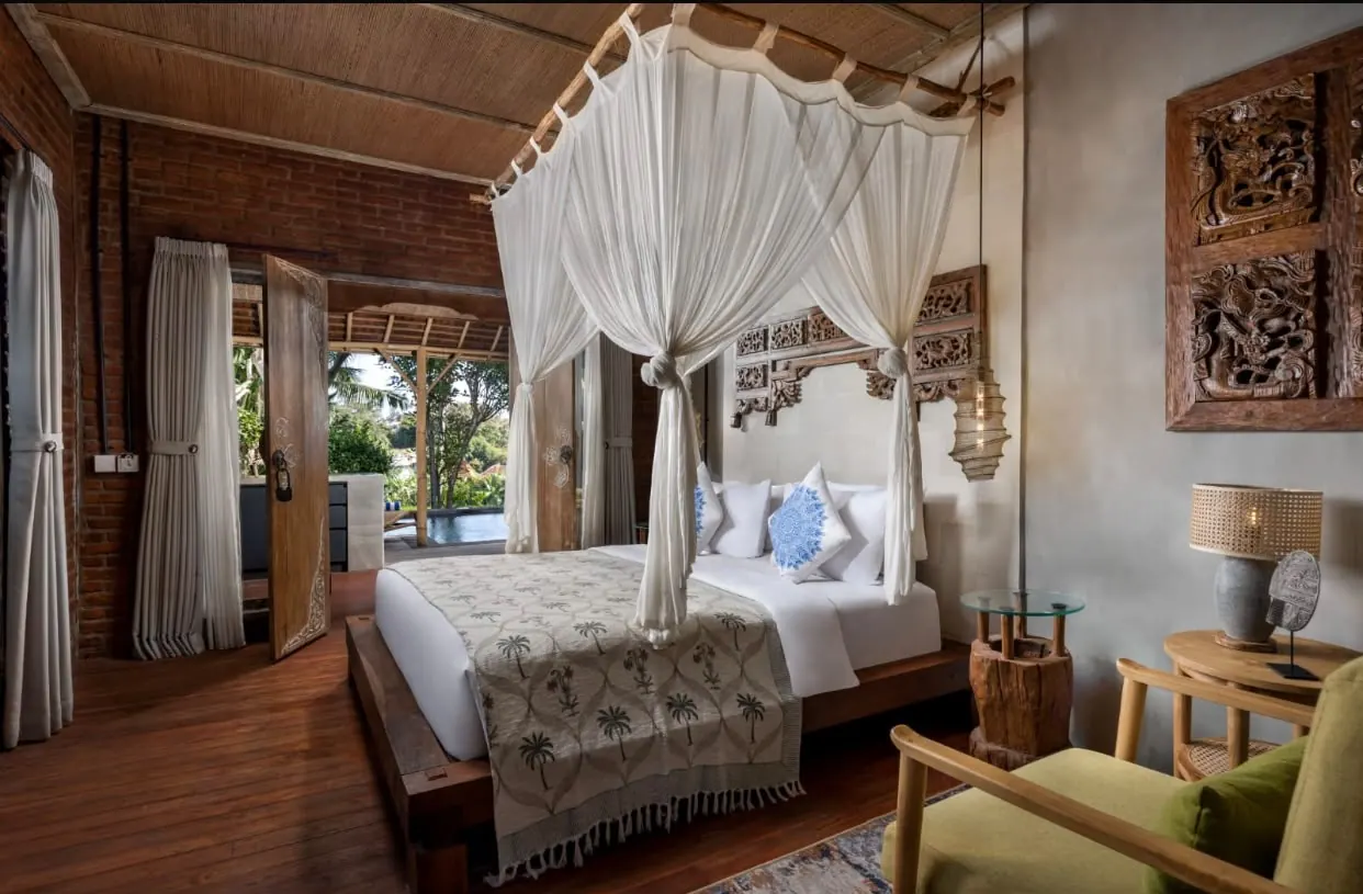 Bedroom with canopy bed opening to the pool