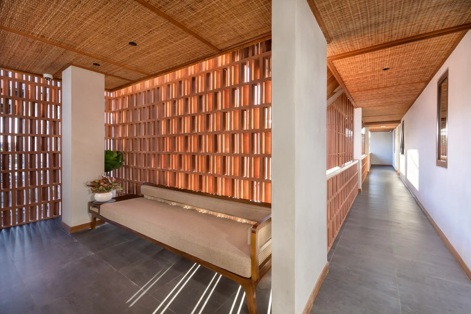 Corridor with terracotta brick screens and lounge bench