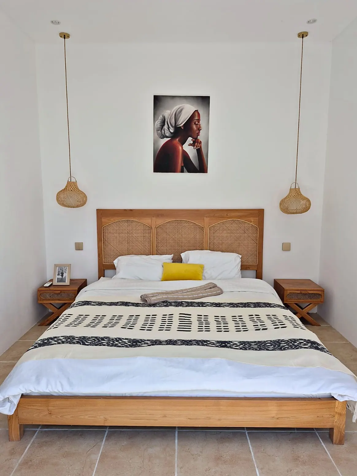 Second bedroom with teak bed and artwork
