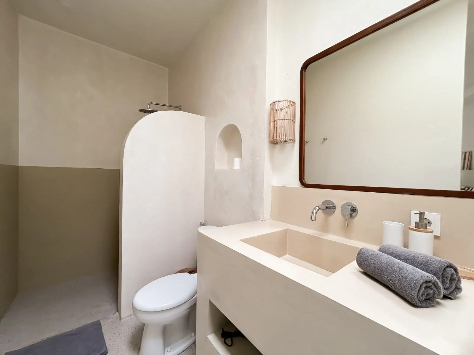 Ensuite bathroom with micro-cement sink and wood-framed mirror