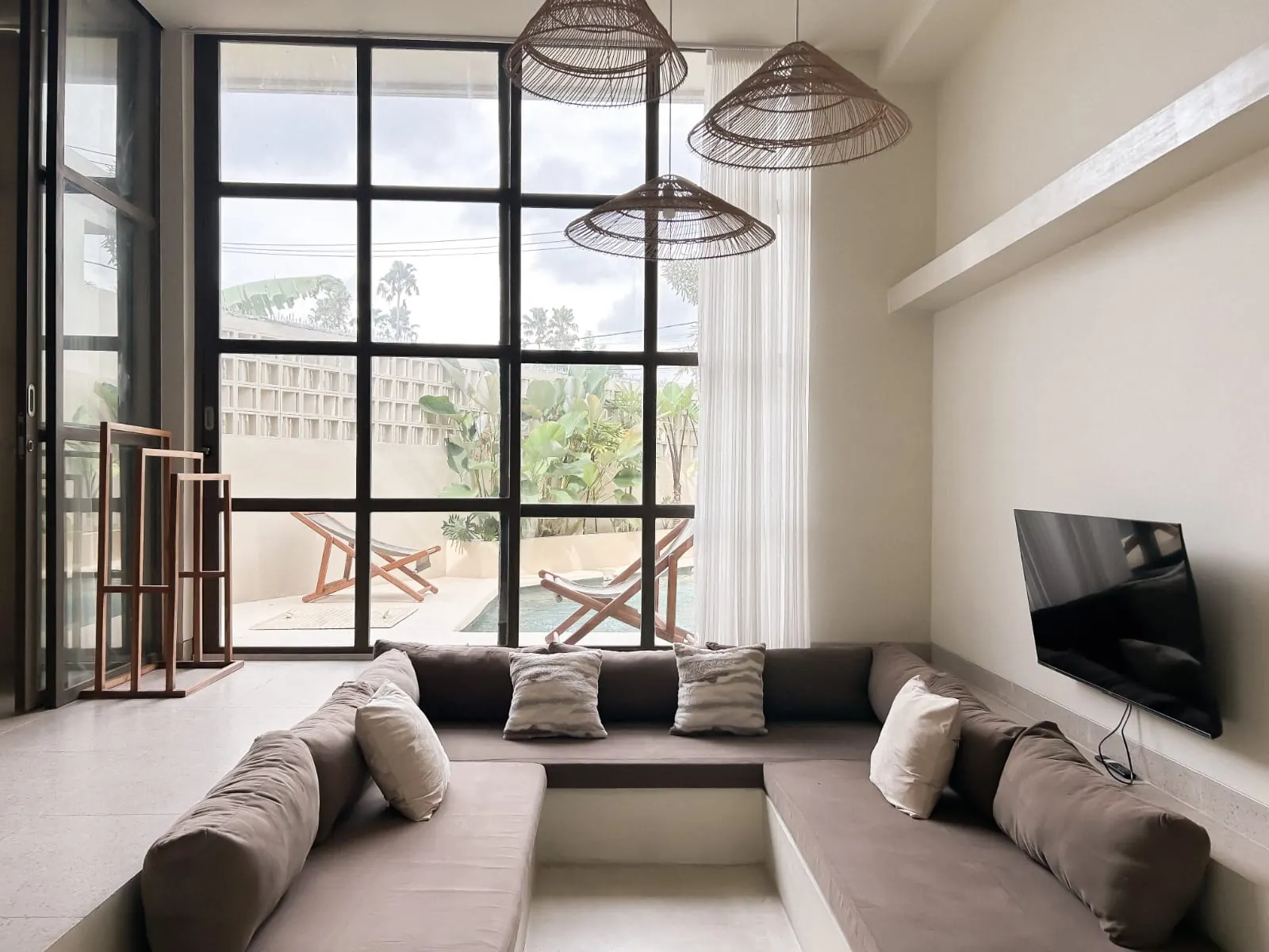 Sunken lounge with rattan pendants, TV and grid windows