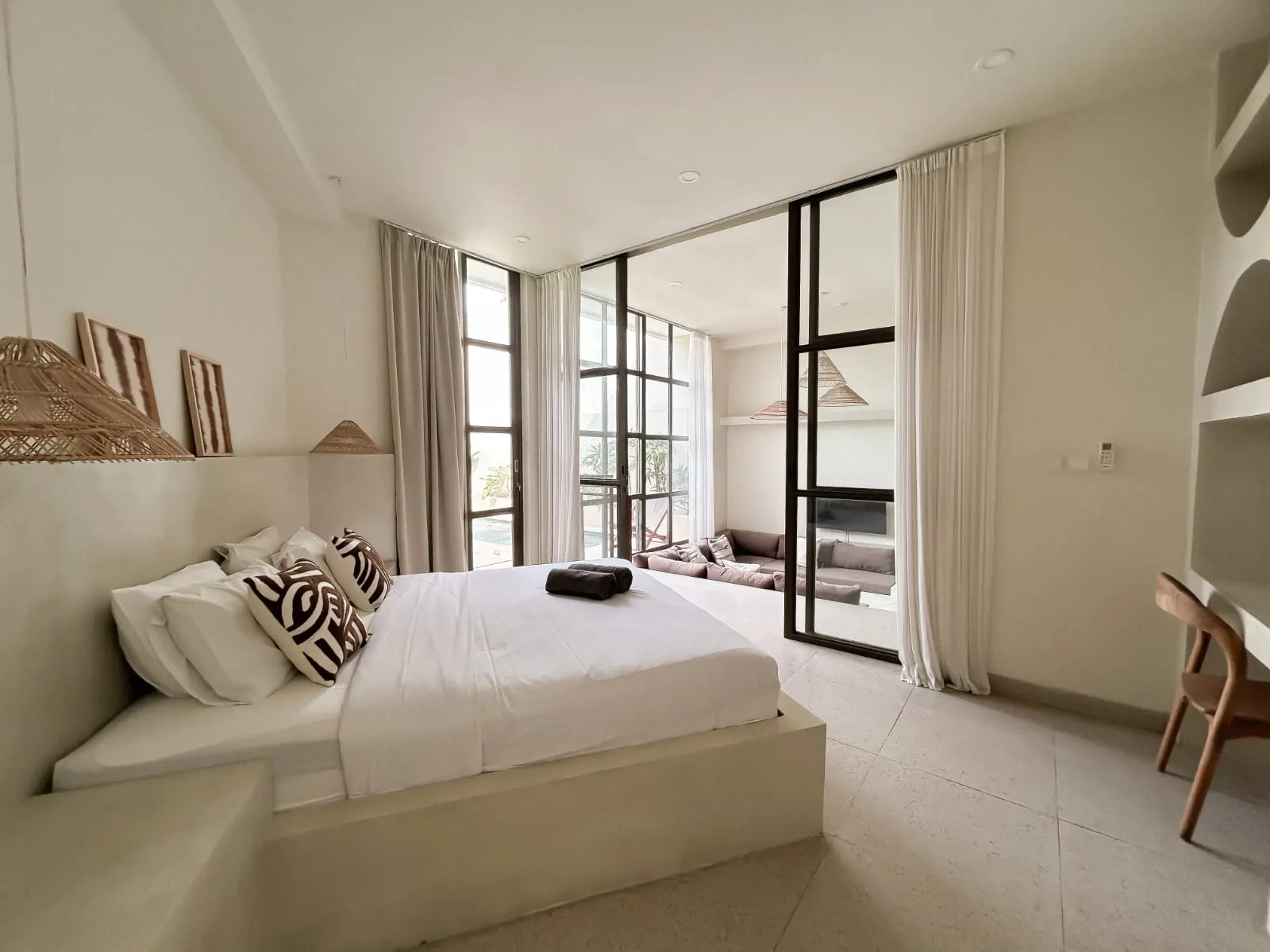 Bedroom with micro-cement platform bed and black glass doors