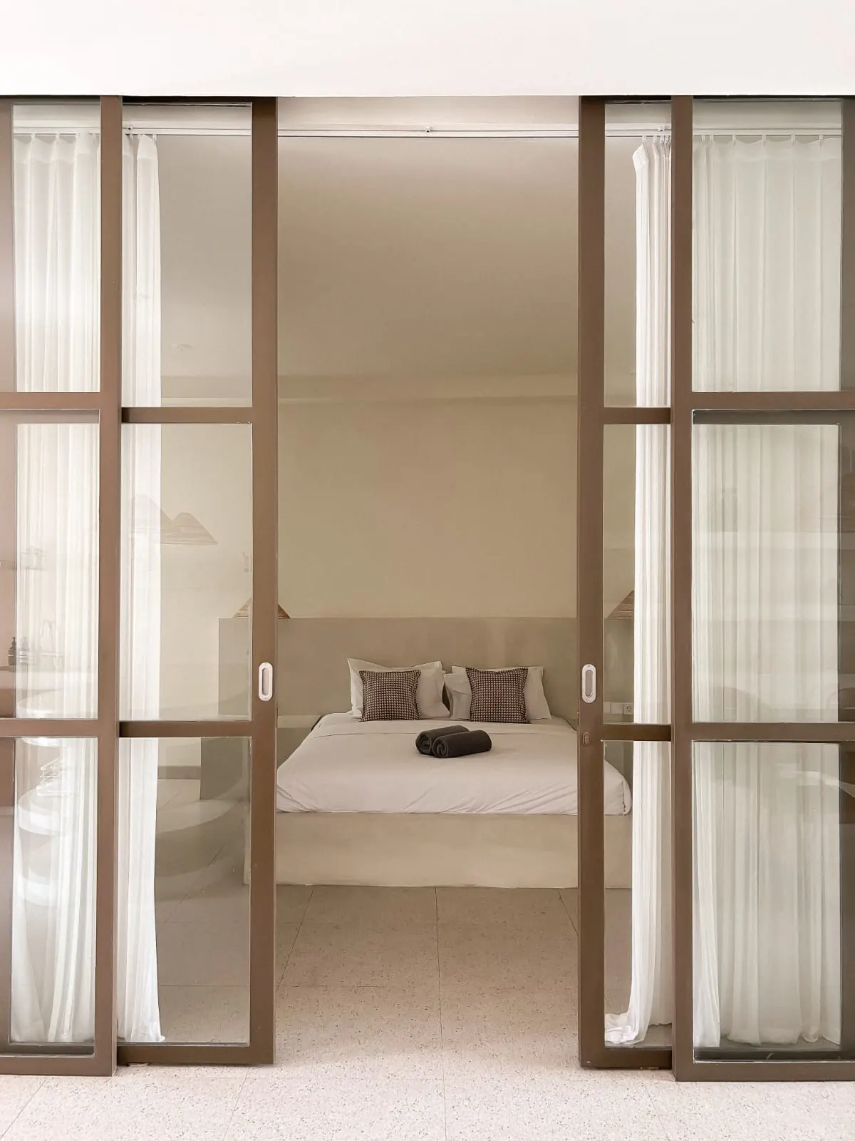 Bedroom seen through black steel glass doors