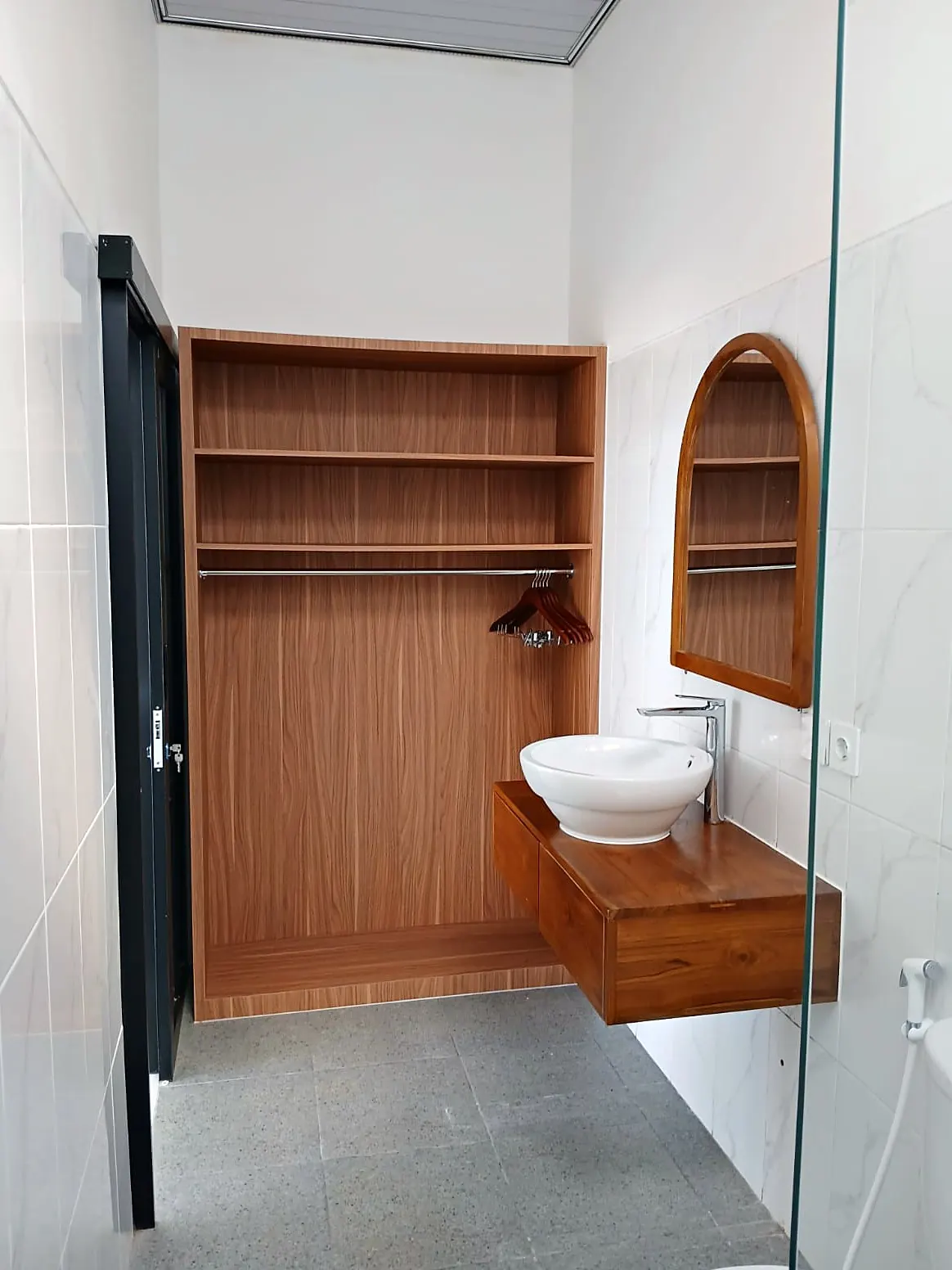 Bathroom with teak vanity and arched mirror