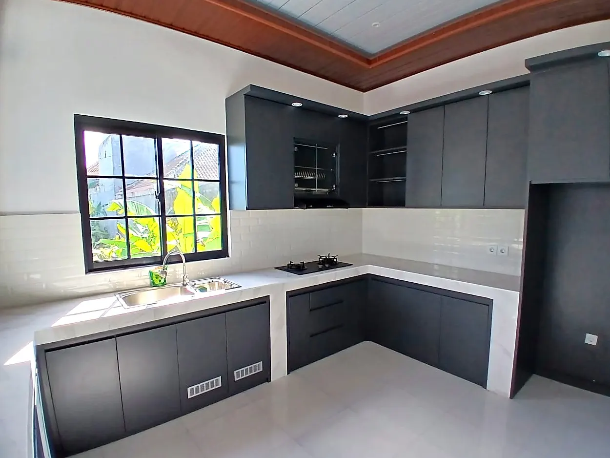 Kitchen with dark cabinets, marble counters and gas hob