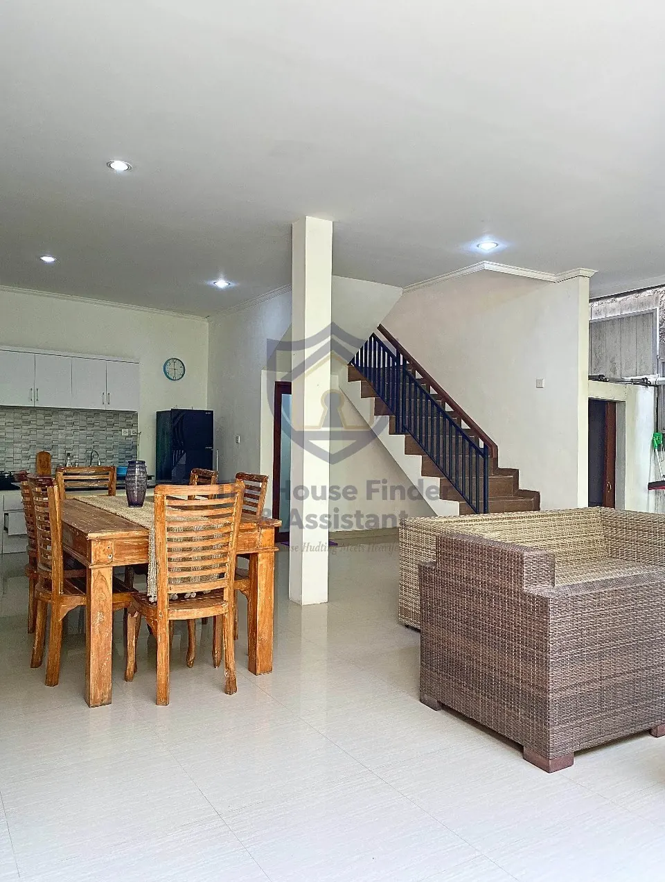 Open-plan living and dining area with rattan sofas and staircase