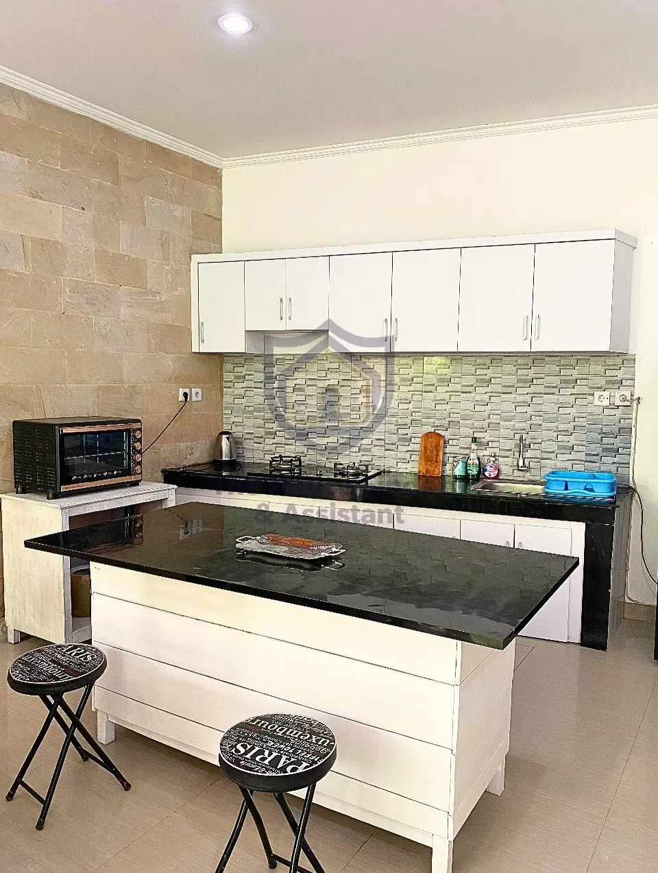 Kitchen with island, black counters and white cabinets