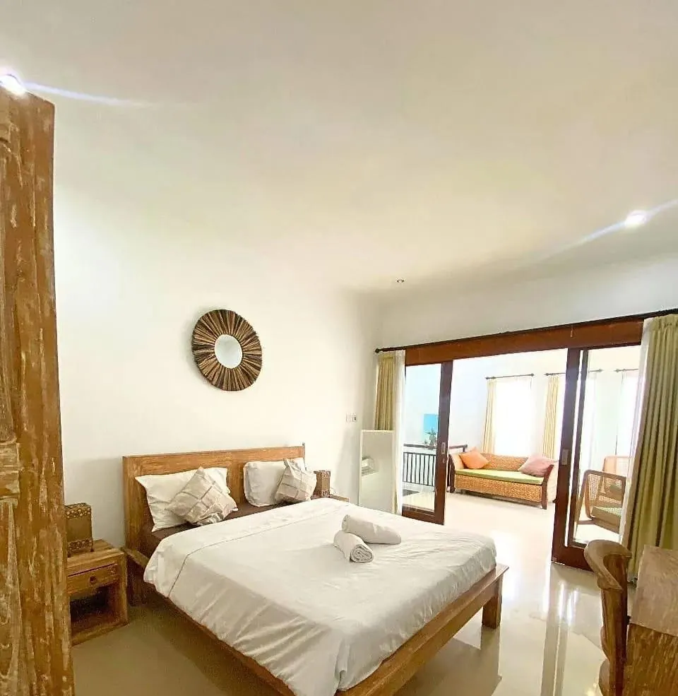 Bedroom with teak bed and sliding doors to the upstairs lounge