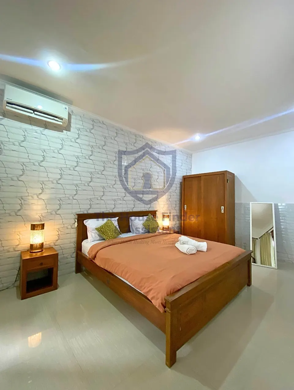 Air-conditioned bedroom with brick-effect feature wall and wardrobe