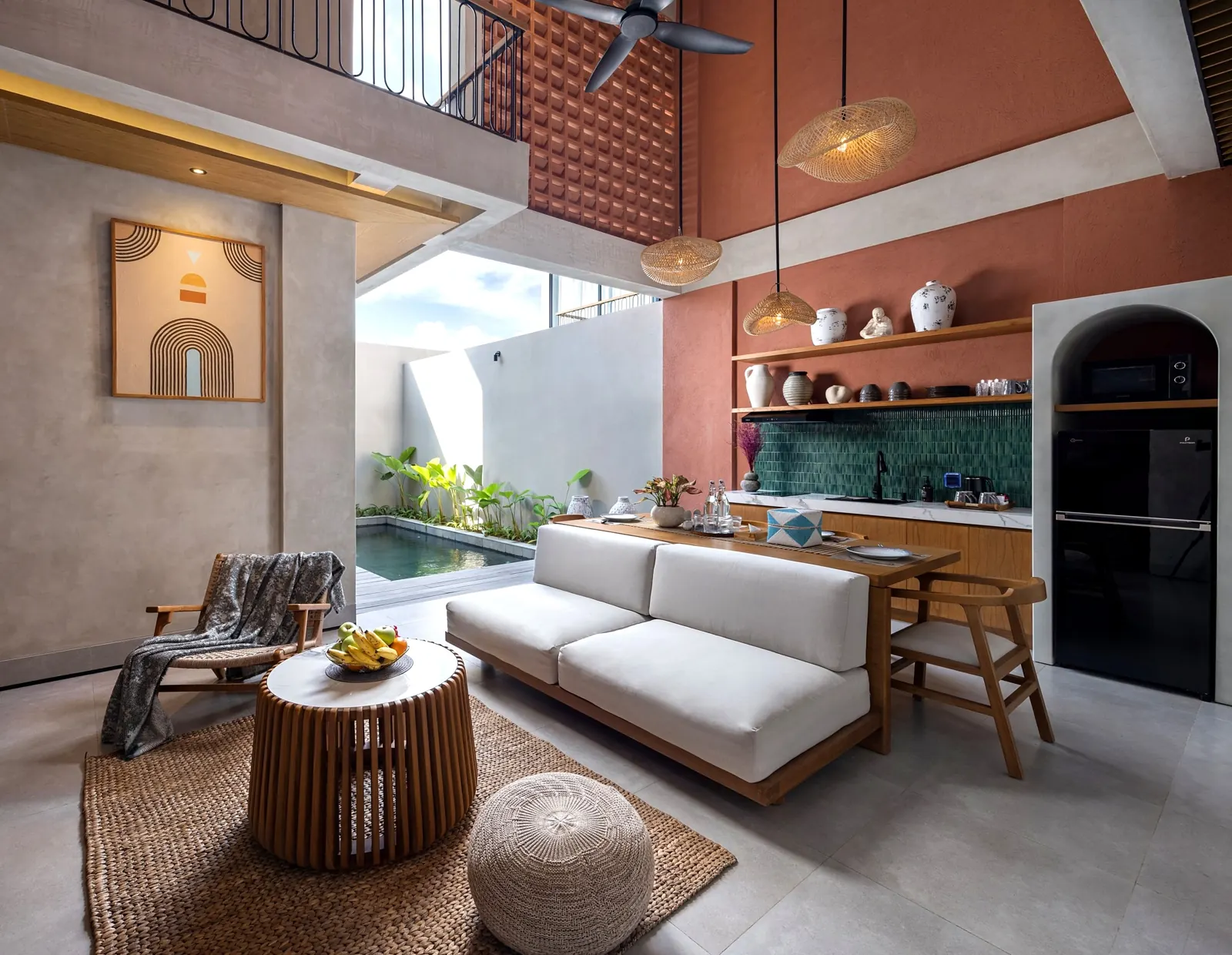 Double-height open-air living room with kitchen and pool view