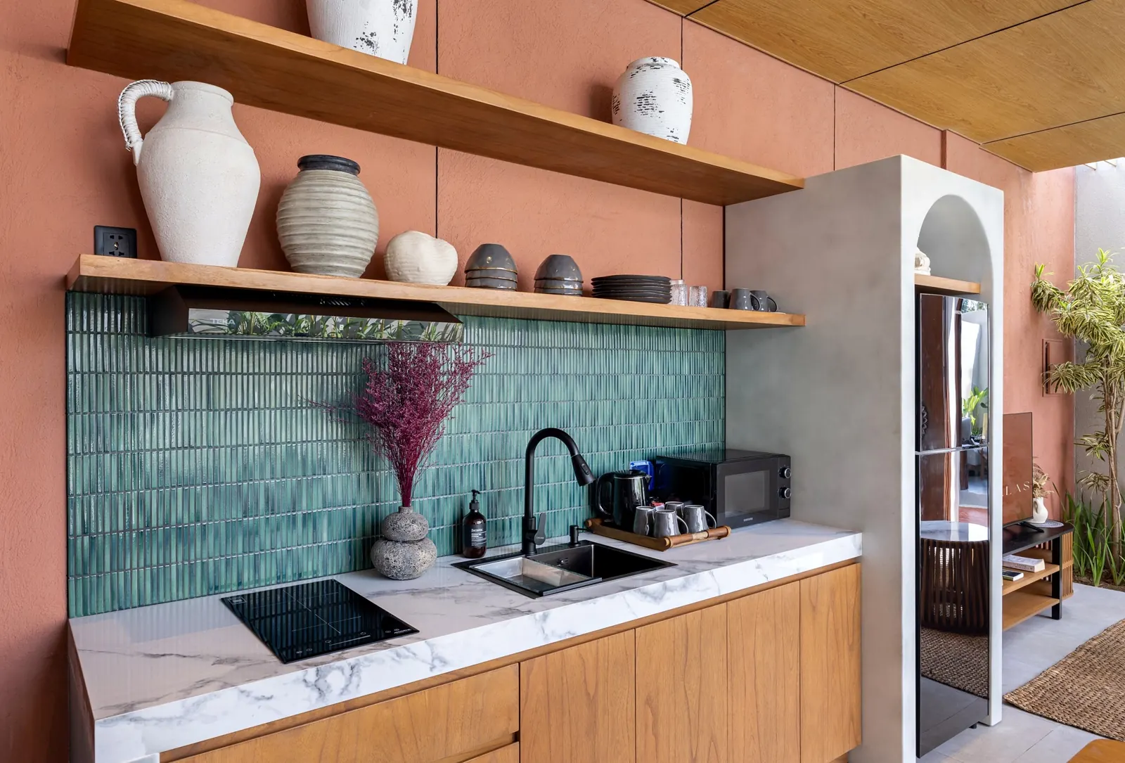 Kitchen with green tiles, marble counter and open shelving