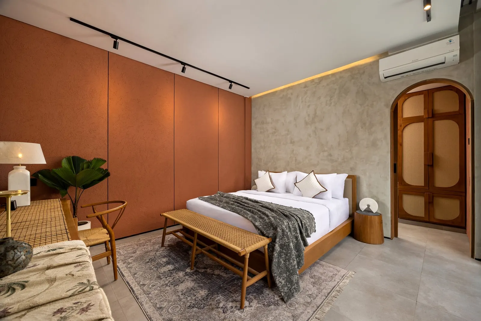 Main bedroom with terracotta wall and arched wardrobe