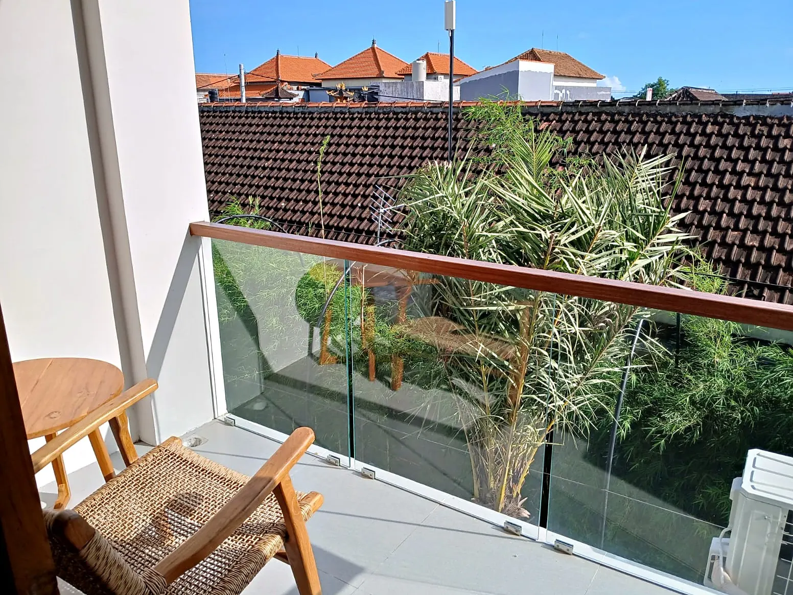 Private balcony with glass railing and rooftop view